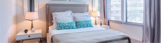 gray bed with blue pillows
